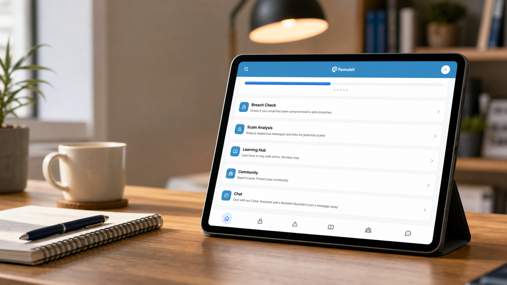 Remaleh Protect app open on a tablet beside a notebook and cup.